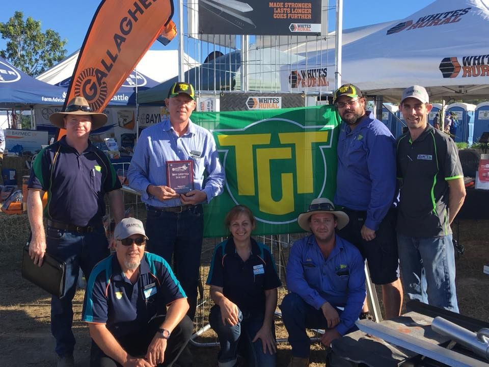 A Group Of People Posing For A Picture In Front Of A Sign That Says Tgt — TGT Pty Ltd in Mareeba, QLD