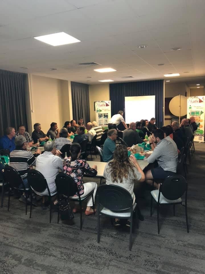 A Group Of People Are Sitting At Tables In A Room — TGT Pty Ltd in Mareeba, QLD