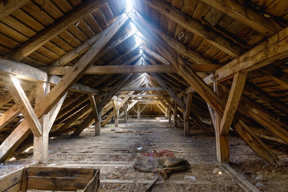 A wooden attic with a roof and a lot of wooden beams.