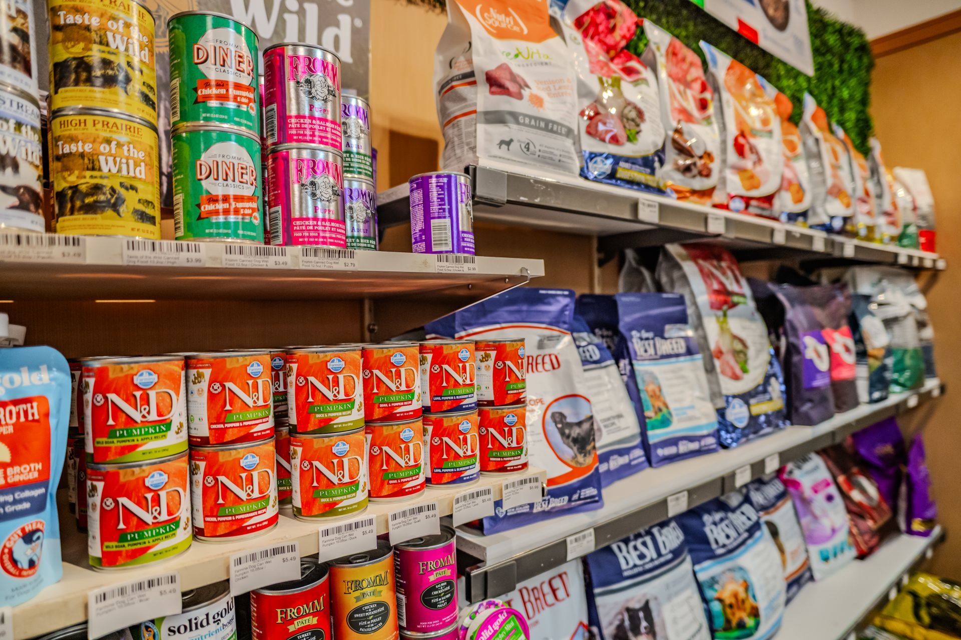 Shelves stocked with various brands of pet food, including cans and bags.