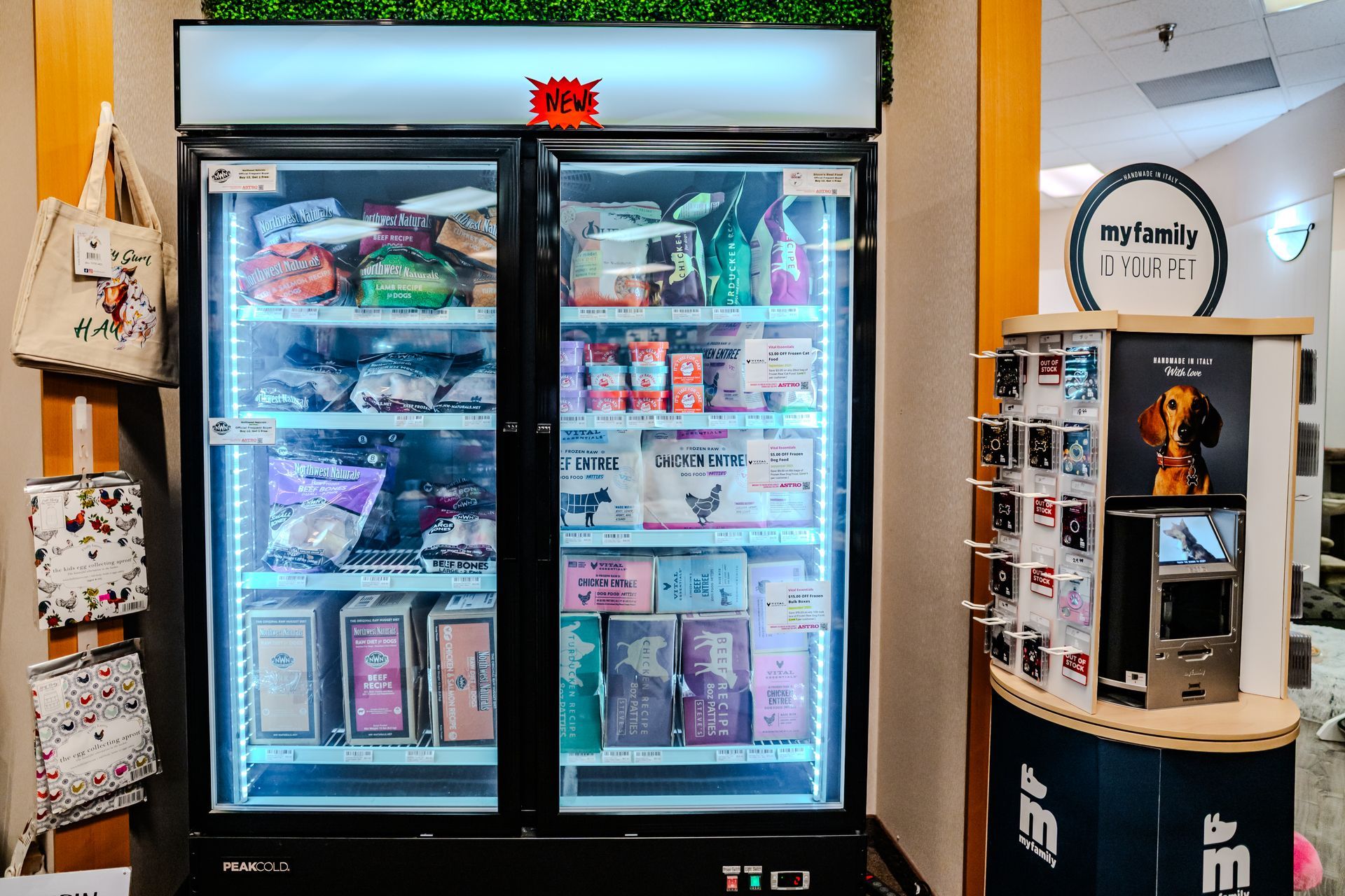 Refrigerator with pet food inside a store, next to a display of photos.