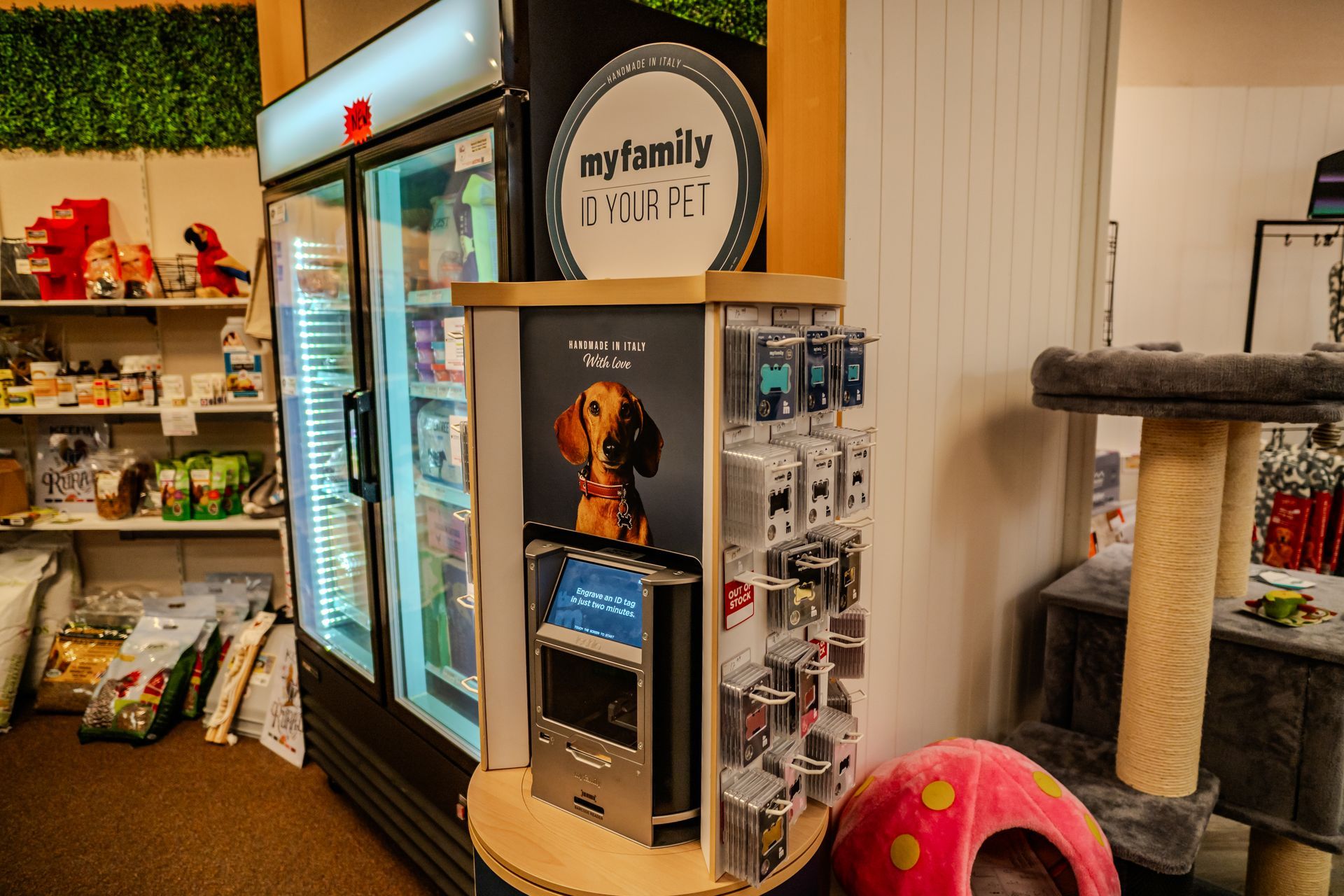 Pet store interior with a refrigerator, product display, and cat tree.
