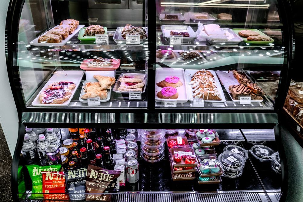 Display case filled with pastries and drinks; snacks and sweets on display.