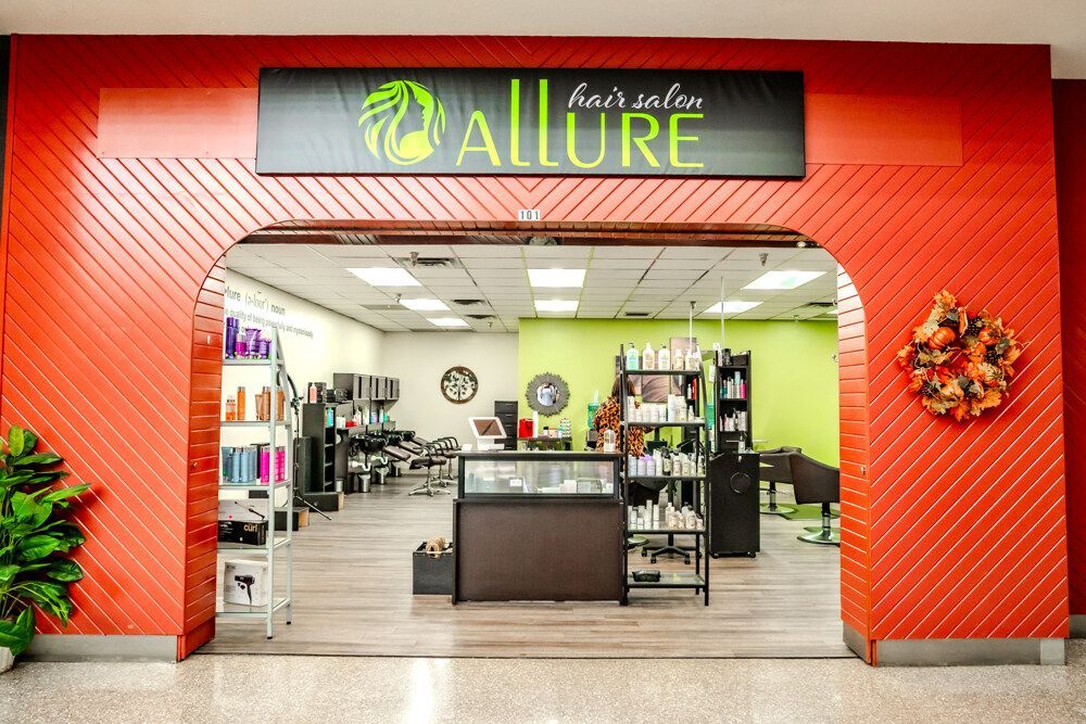 Hair salon entrance with red facade. Allure sign above archway.