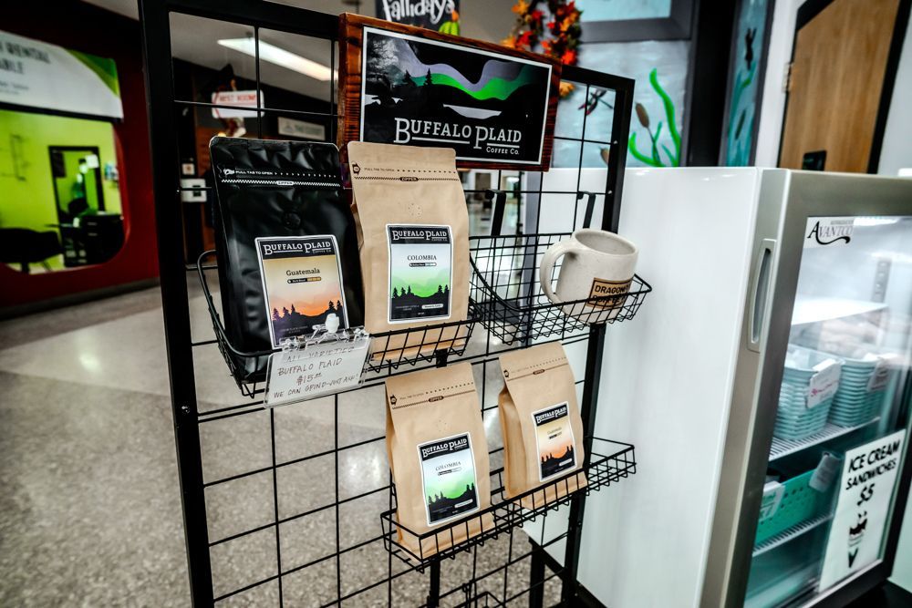 Coffee bags on display at a store, with a sign reading 