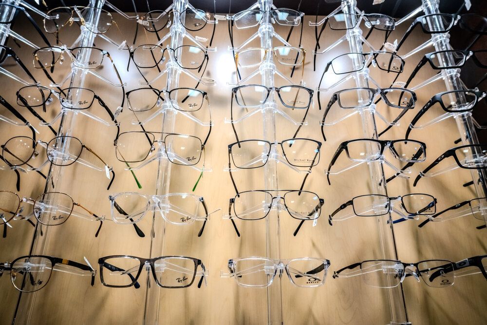 Eyeglasses display with various frame styles in a well-lit store setting.