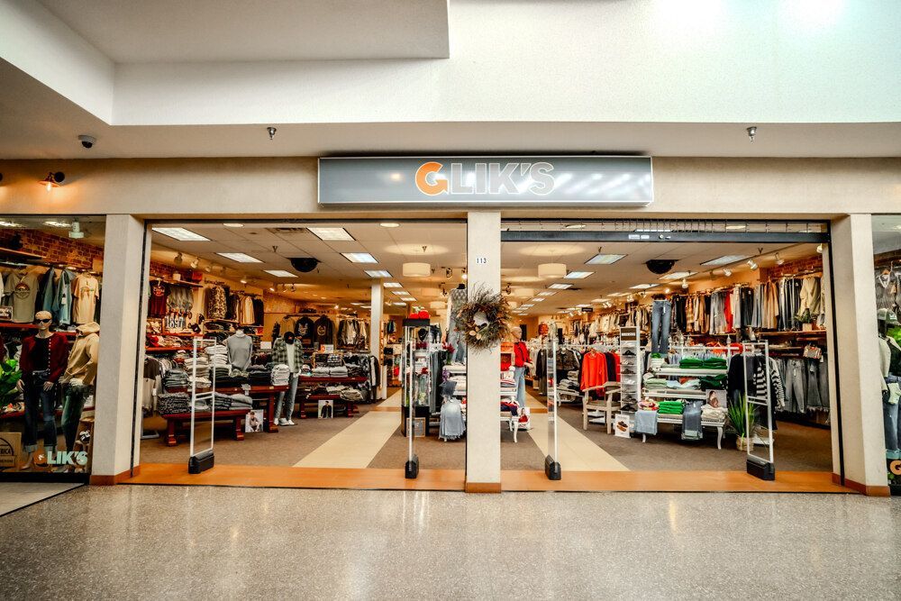 Storefront of Gander Outdoors inside a mall. Beige exterior, open doors, merchandise visible inside, security gates present.
