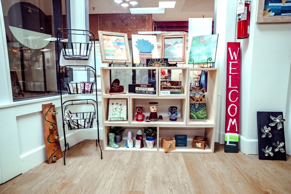 Display of art and gift items on shelves and racks in a store. 
