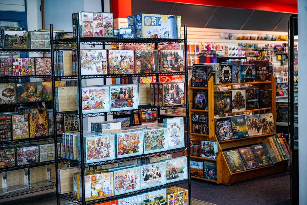 Shelves filled with board games in a store; various box sizes and colorful game covers.
