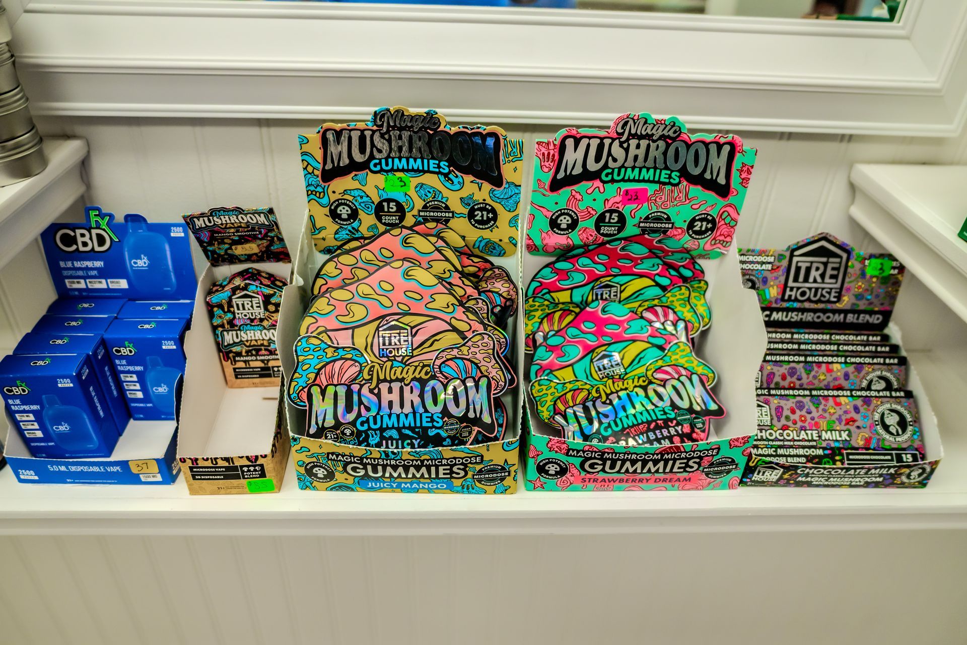 Shelf display with colorful packages of mushroom gummies and CBD products.