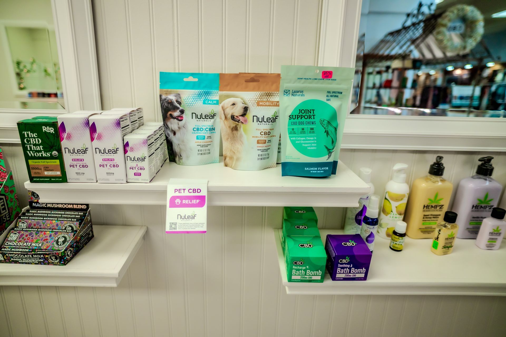 Shelves displaying pet products and topical creams in a store setting.