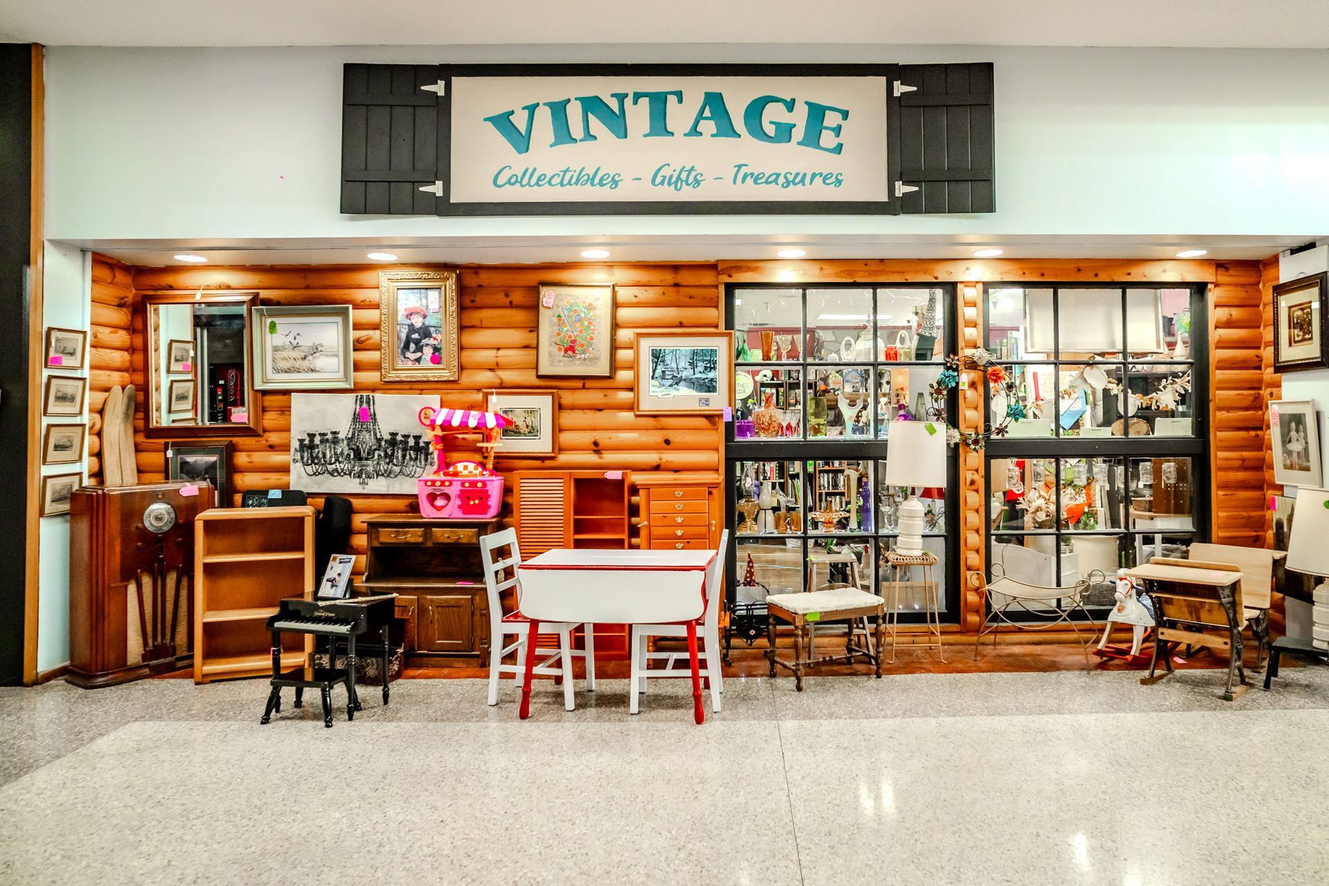 Vintage store front with wooden log siding, items displayed, and signage.