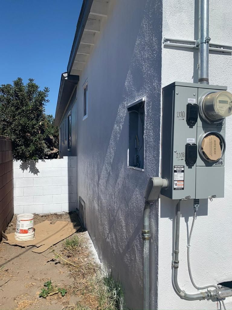 A white house with a meter on the side of it.