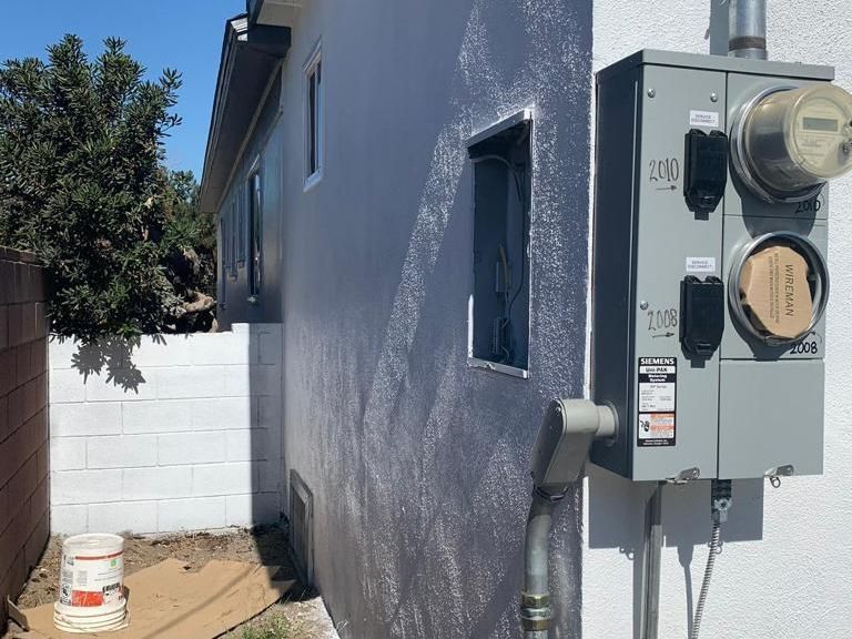A white house with a meter on the side of it
