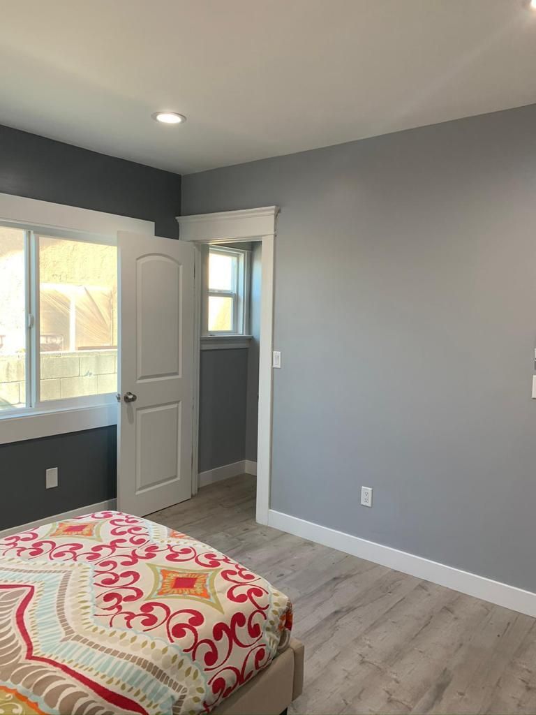 A bedroom with a bed , a window and a door.