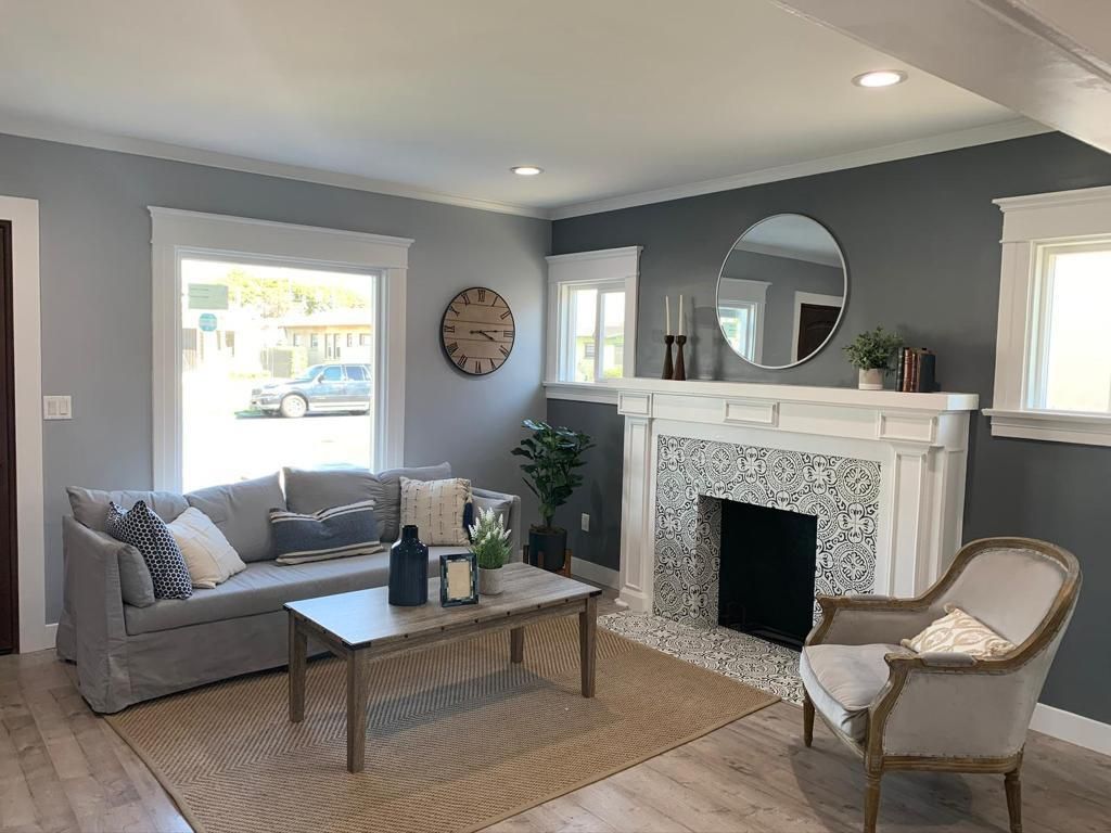 A living room with a couch , chair , coffee table and fireplace.