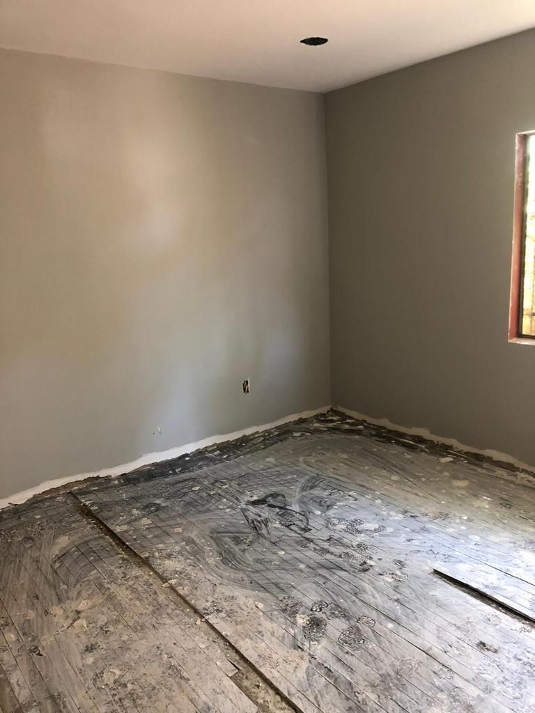 An empty room with a wooden floor and a window.