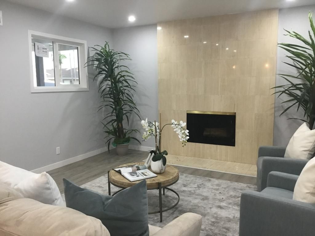 A living room with a fireplace , couch , chairs and a table.