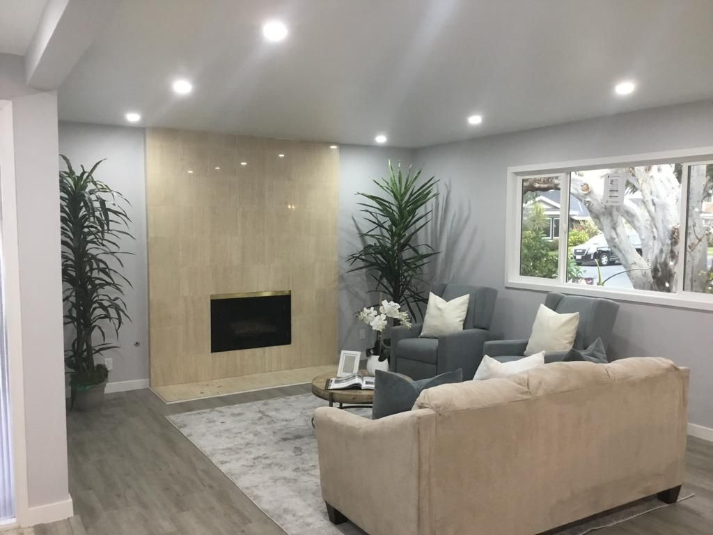 A living room with a couch , chairs , and a fireplace.