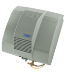 A gray whole-house humidifier, mounted on a wall, with water and air supply lines.