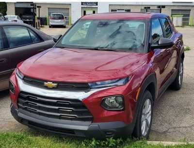 A woman is sitting in a car with a man behind her.
