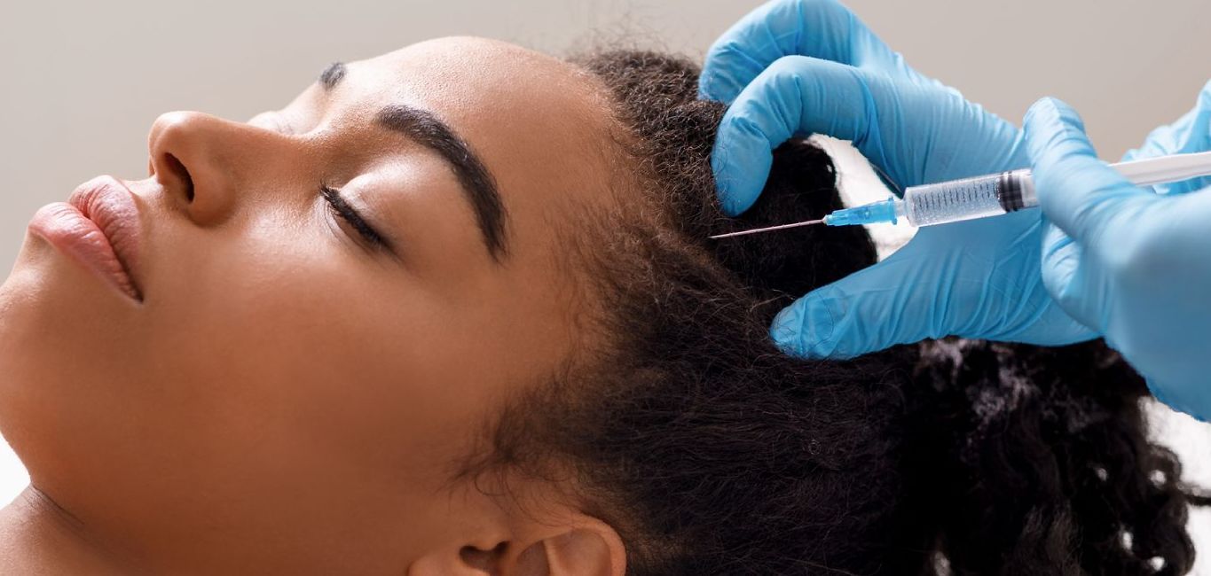 A woman is getting a botox injection in her head.