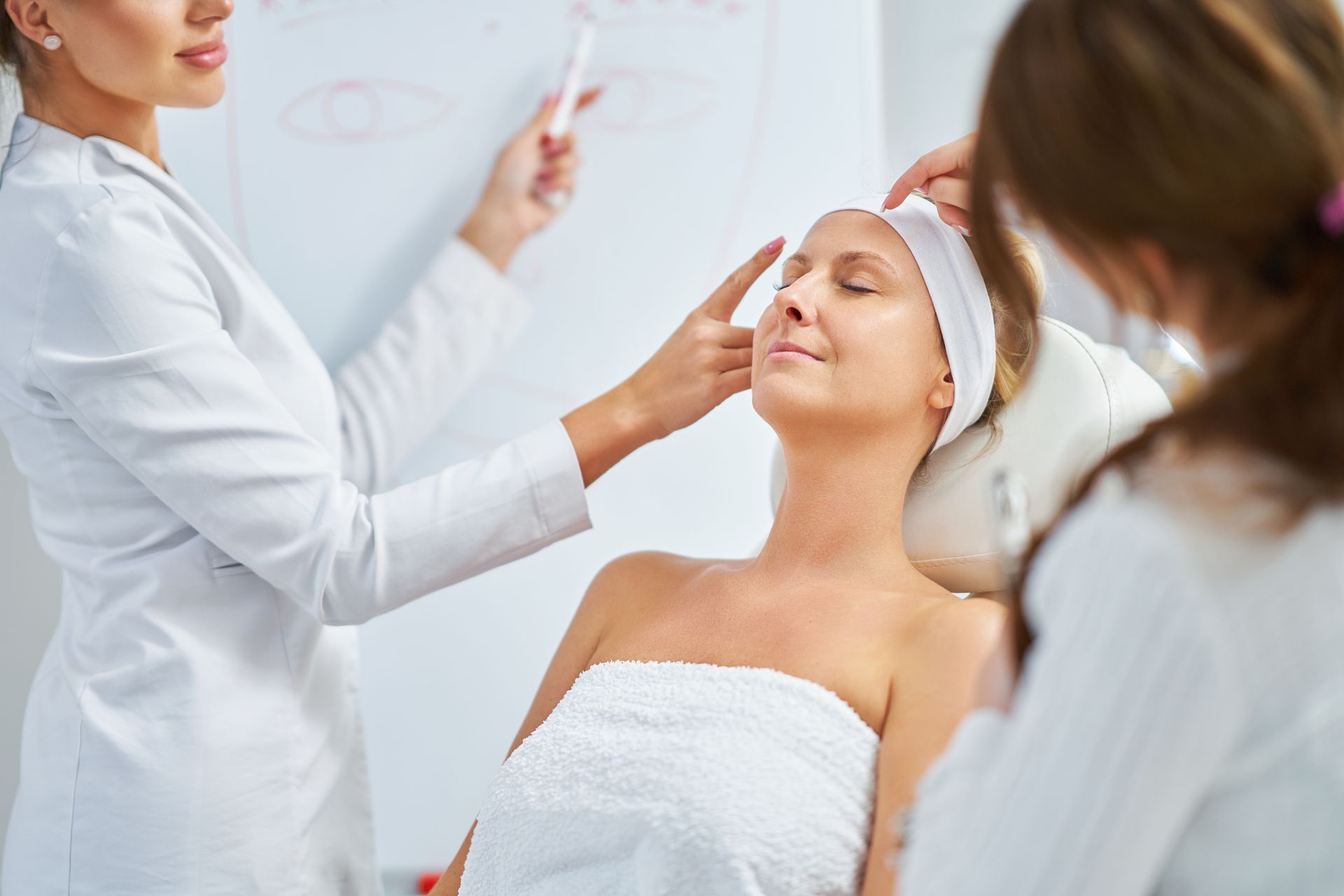 A woman is getting a facial treatment at a beauty salon.