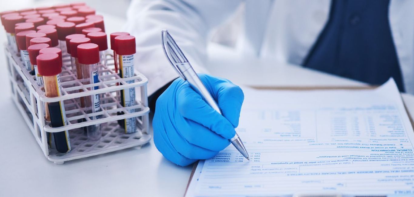 A scientist is writing on a clipboard in a laboratory.