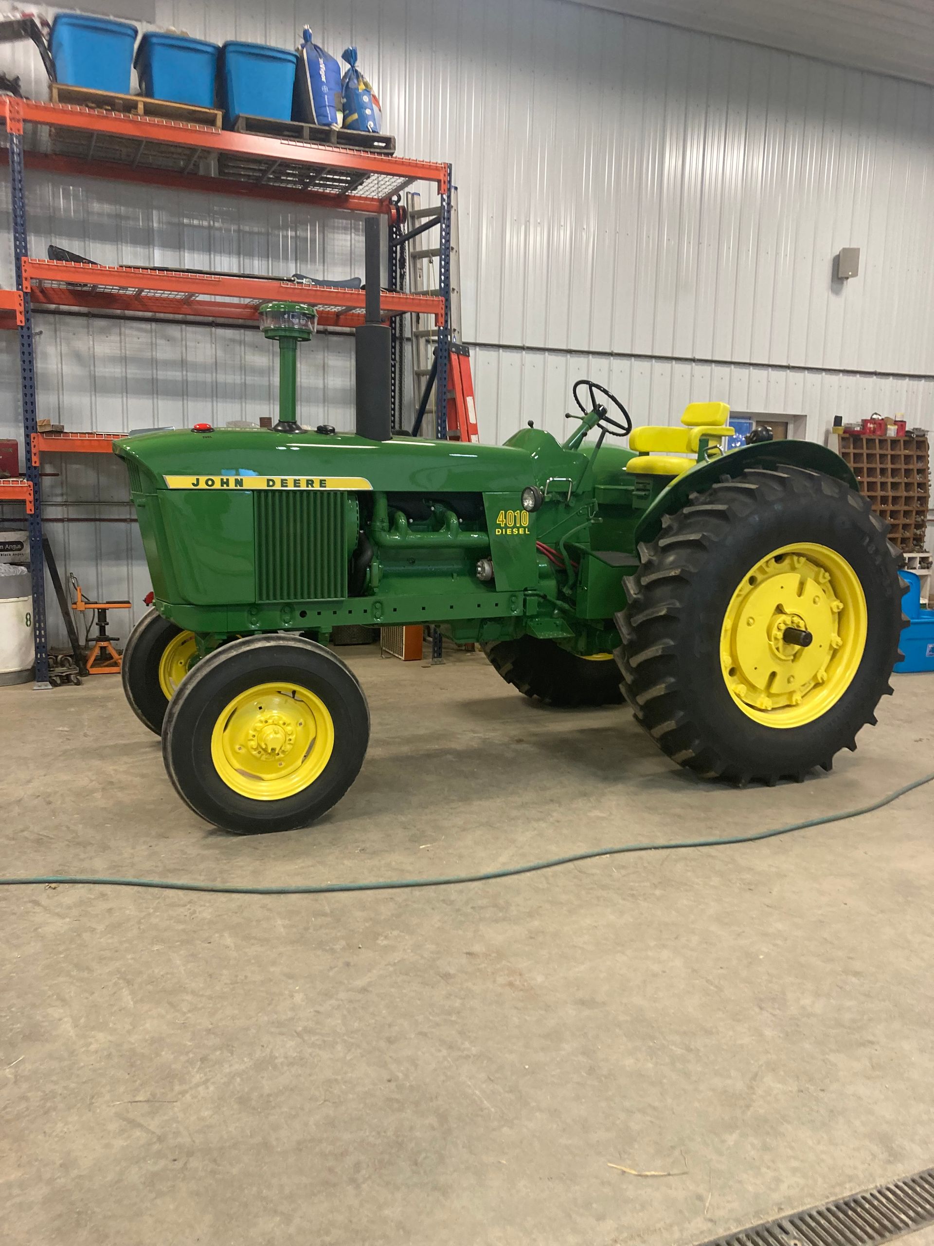 John Deere 4020 tractor, green and yellow, indoors, in a workshop setting.