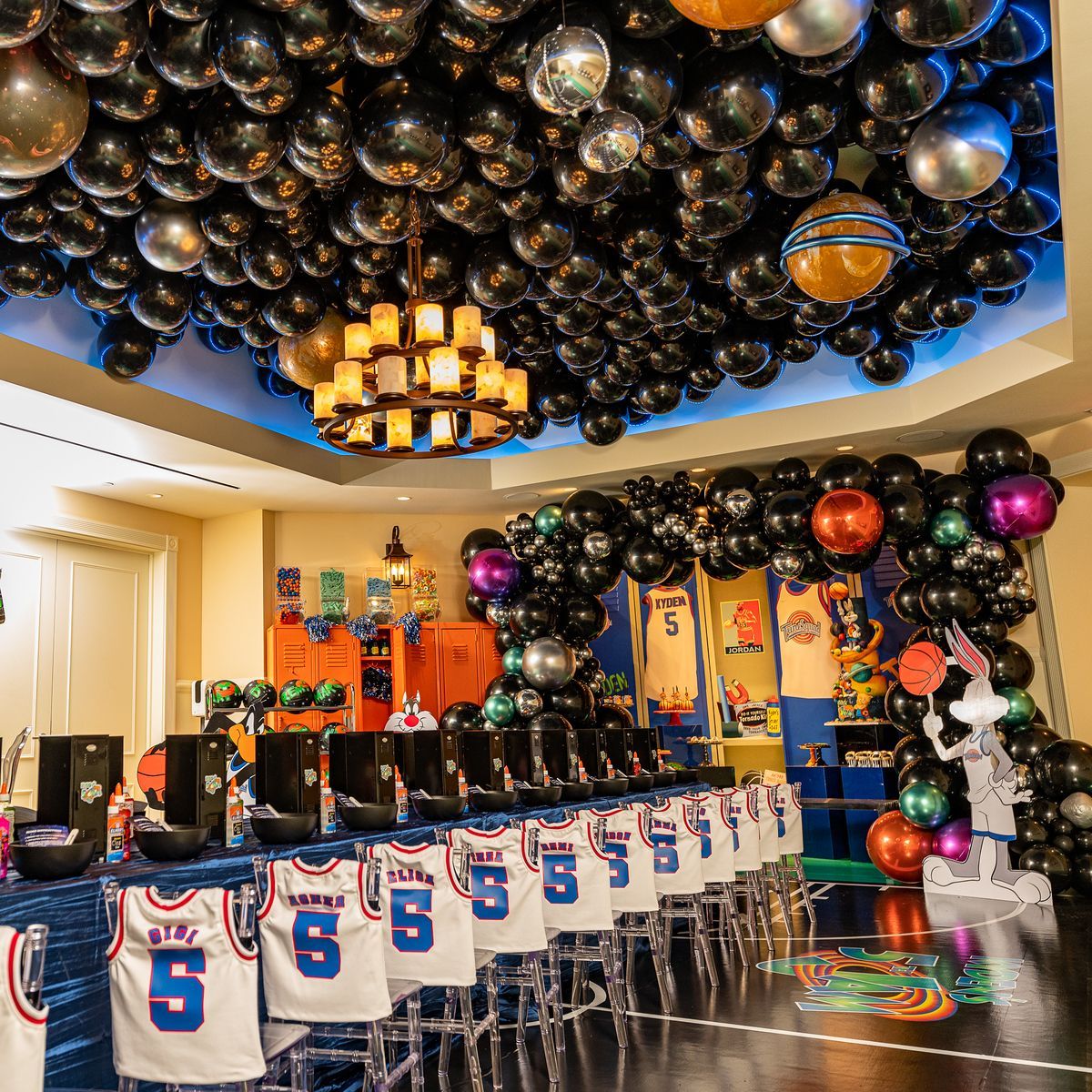 A room filled with lots of balloons and jerseys.