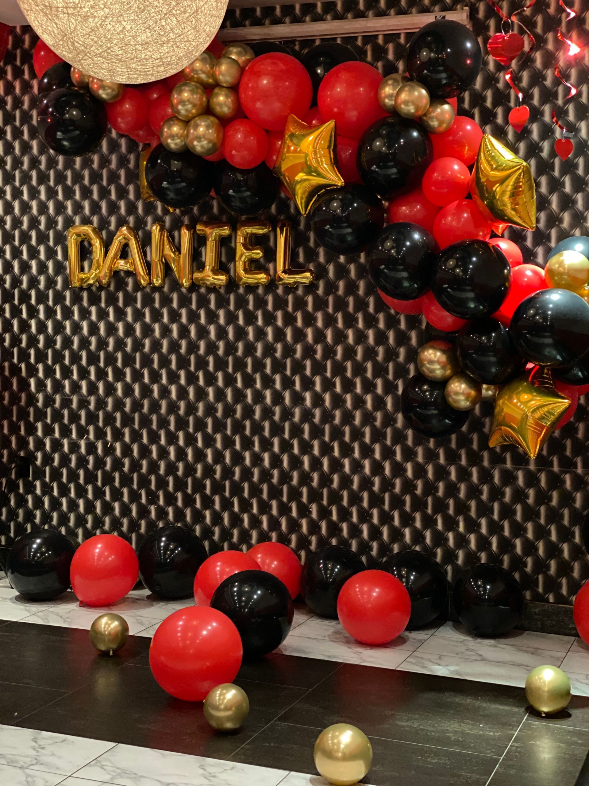 A wall with balloons and the name daniel on it