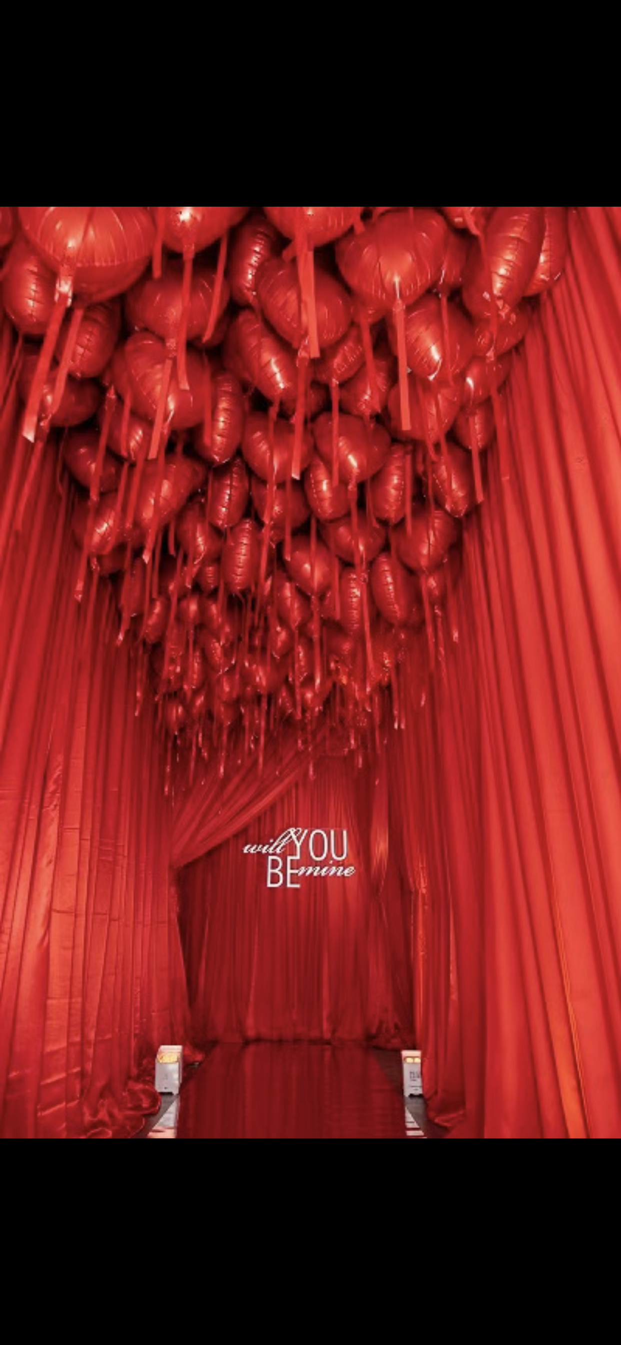 A room filled with red balloons and a sign that says `` you be ''.