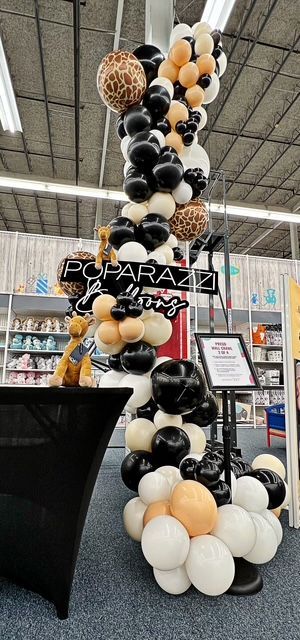 A bunch of balloons are sitting on a stage in a room.