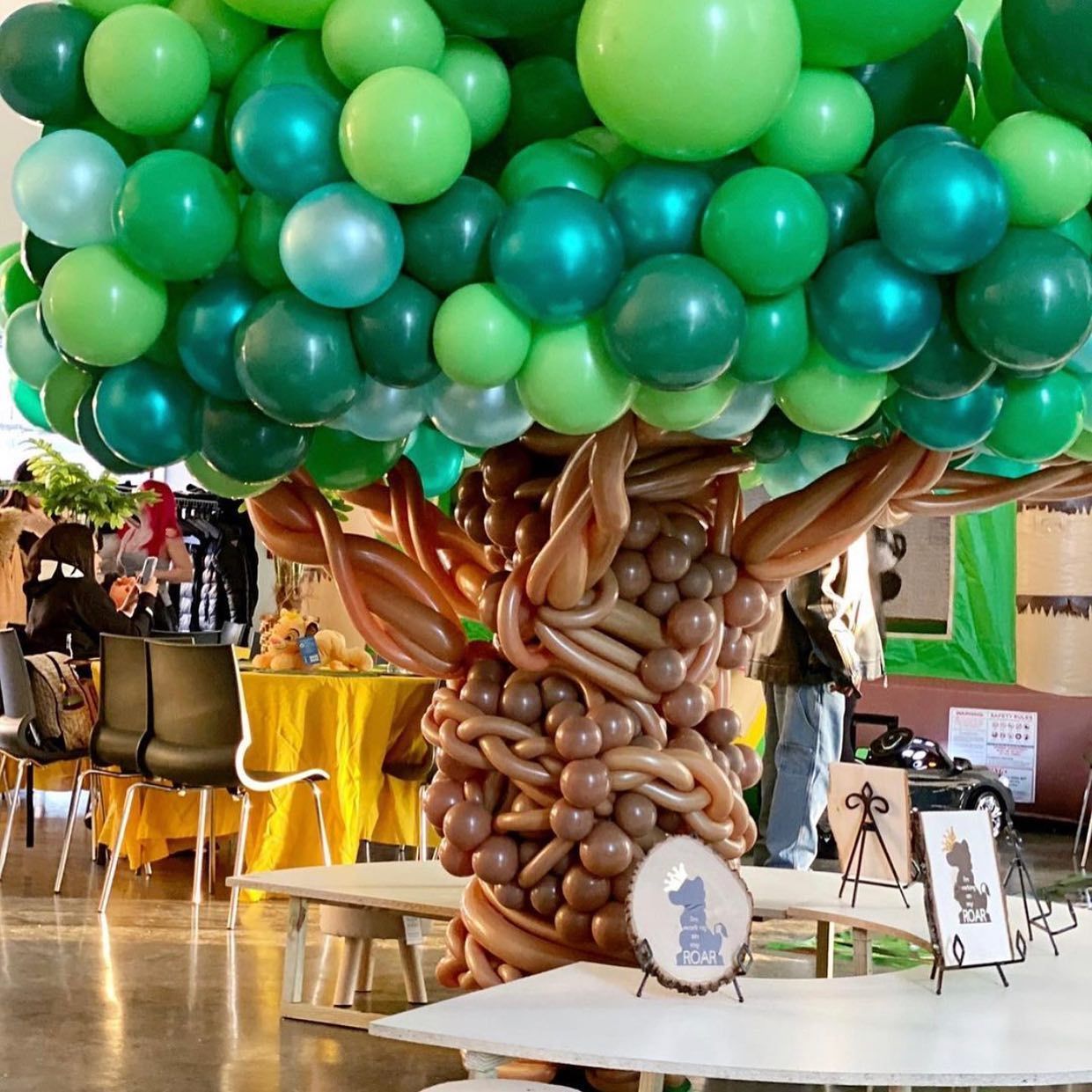 A bunch of gold balloons are stacked on top of each other in a room.
