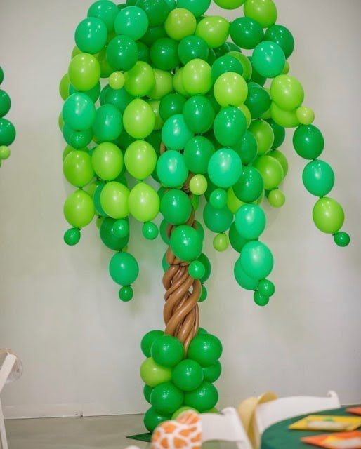 A tree made out of green balloons in a room