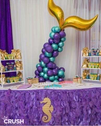 A mermaid tail made of balloons is sitting on top of a table.