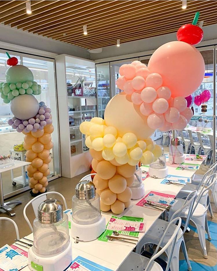 A room decorated with balloons in the shape of ice cream cones.