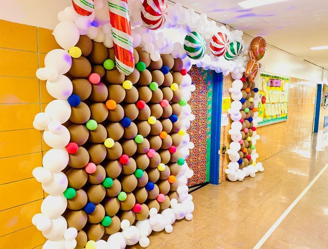 A gingerbread house made out of balloons in a hallway.