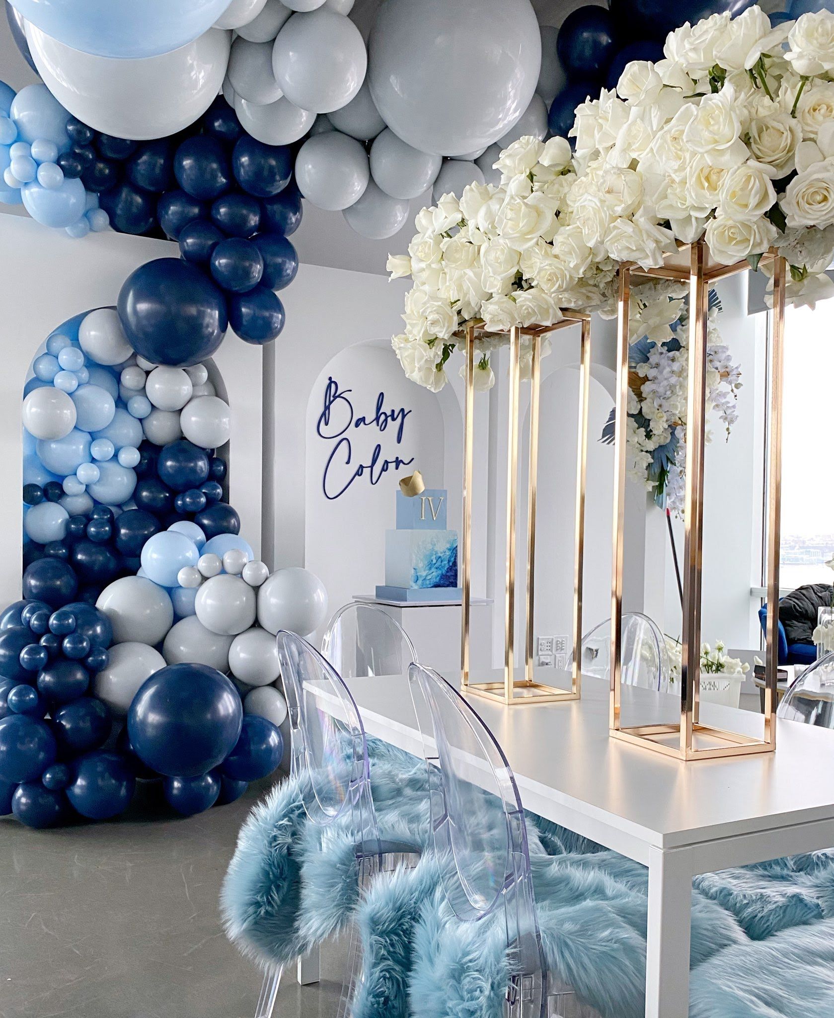A room decorated with blue and white balloons and flowers.