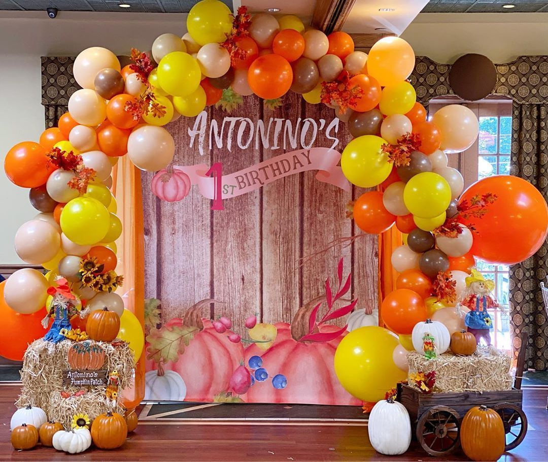 A room decorated with balloons and pumpkins for a birthday party.