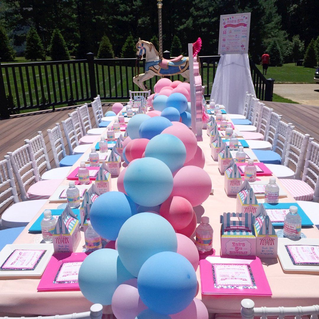 A long table with pink and blue balloons on it