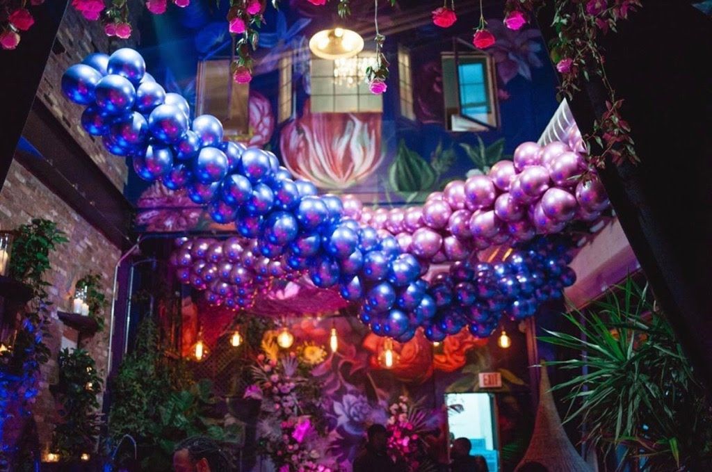 A bunch of balloons are hanging from the ceiling of a room.