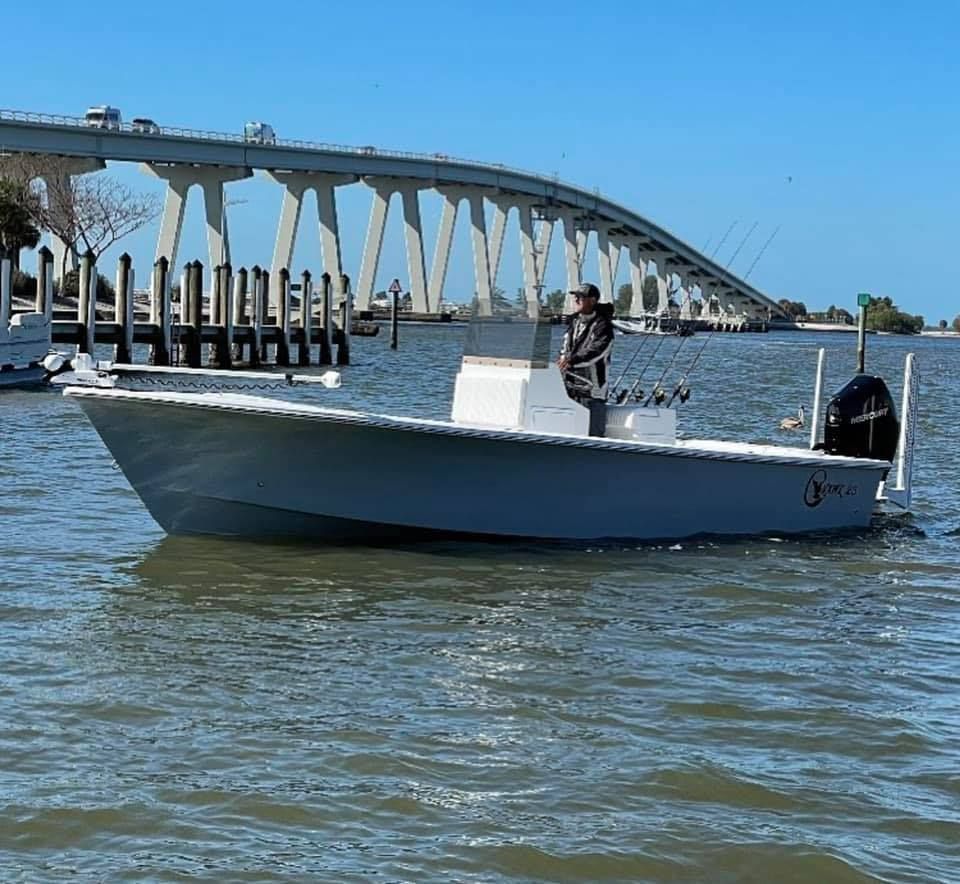 A boat is in Fort Myers, FL with a bridge in the background