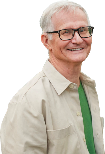 A man wearing glasses and a green shirt is smiling.