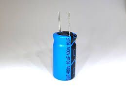A blue and black capacitor is sitting on a white surface.