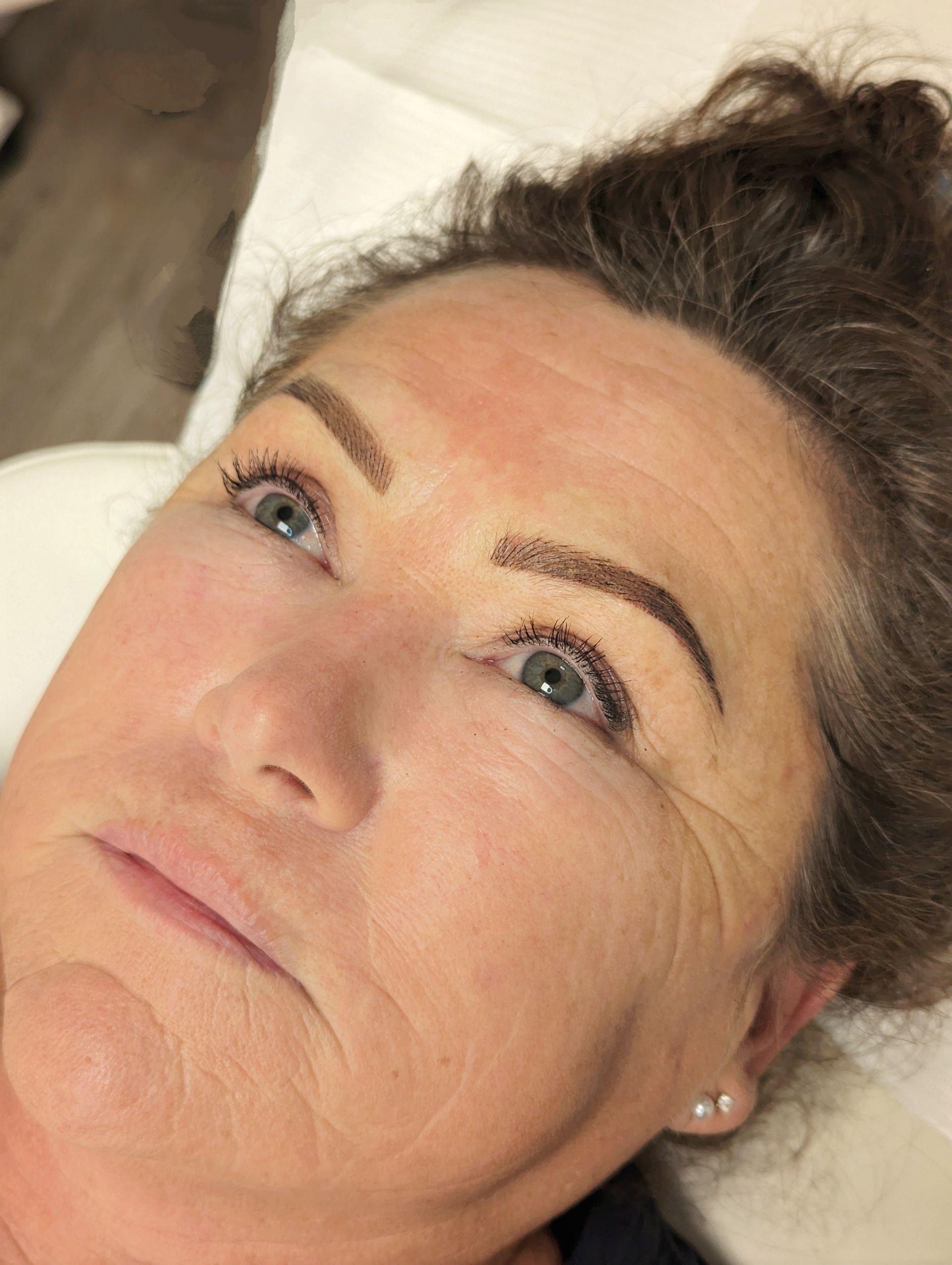 A close up of a woman 's face with a tattoo on her eyebrows.