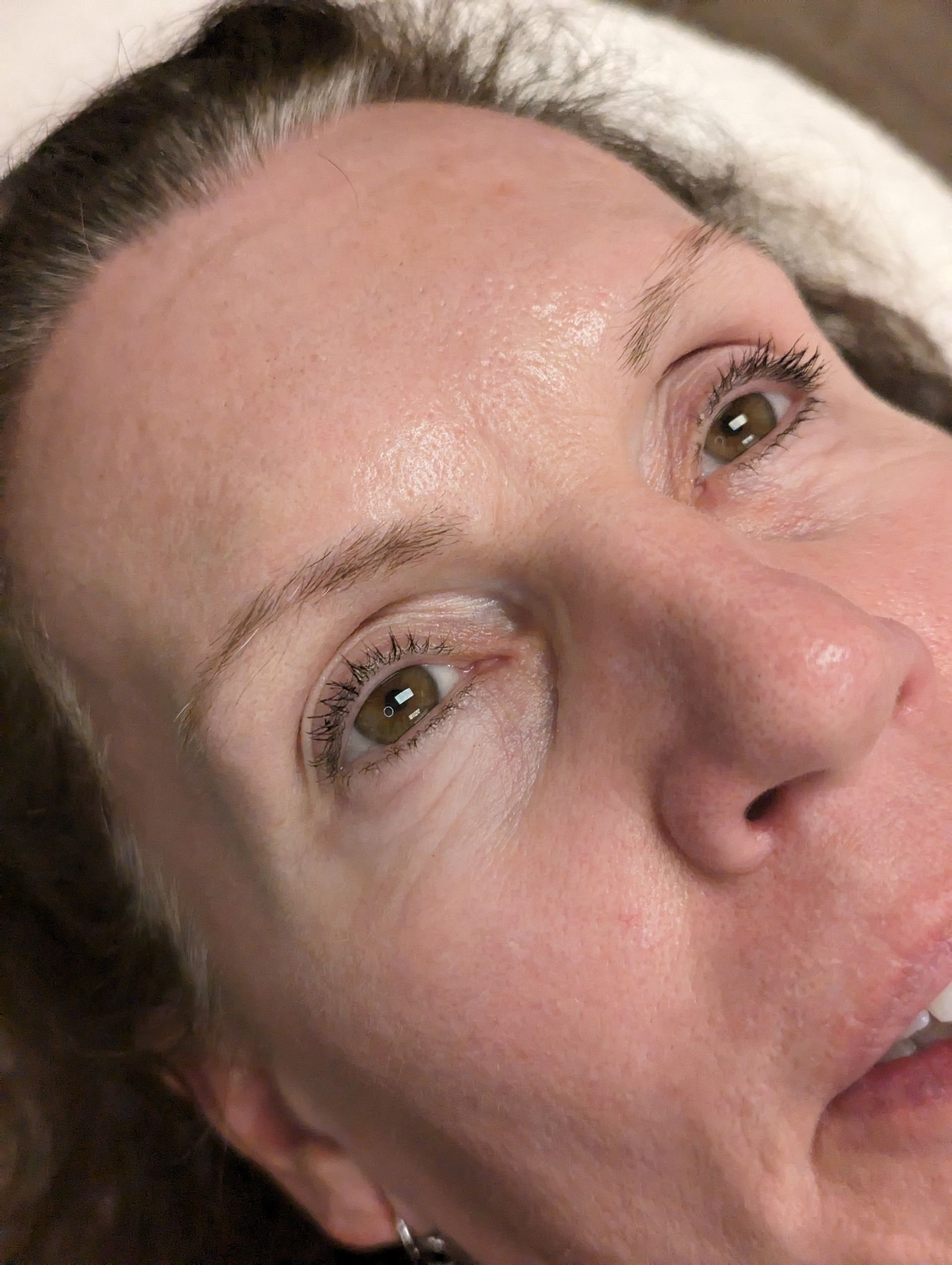 A close up of a woman 's face with sweat on her forehead.