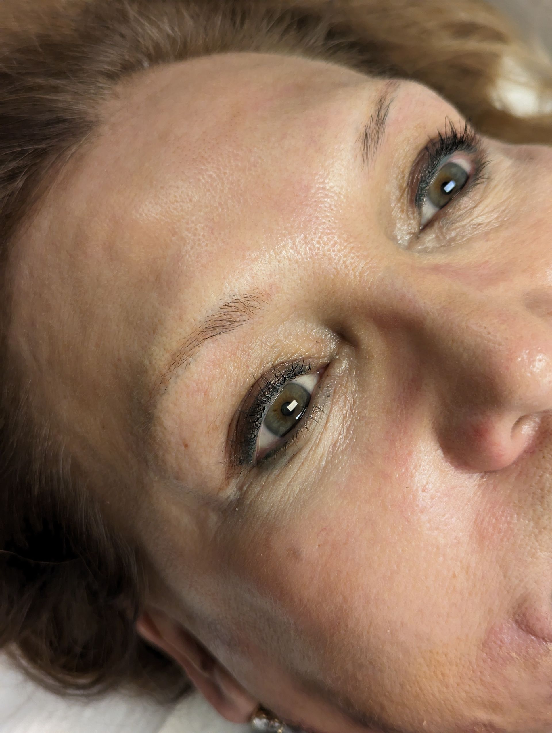 A close up of a woman 's face with a tattoo on her forehead.