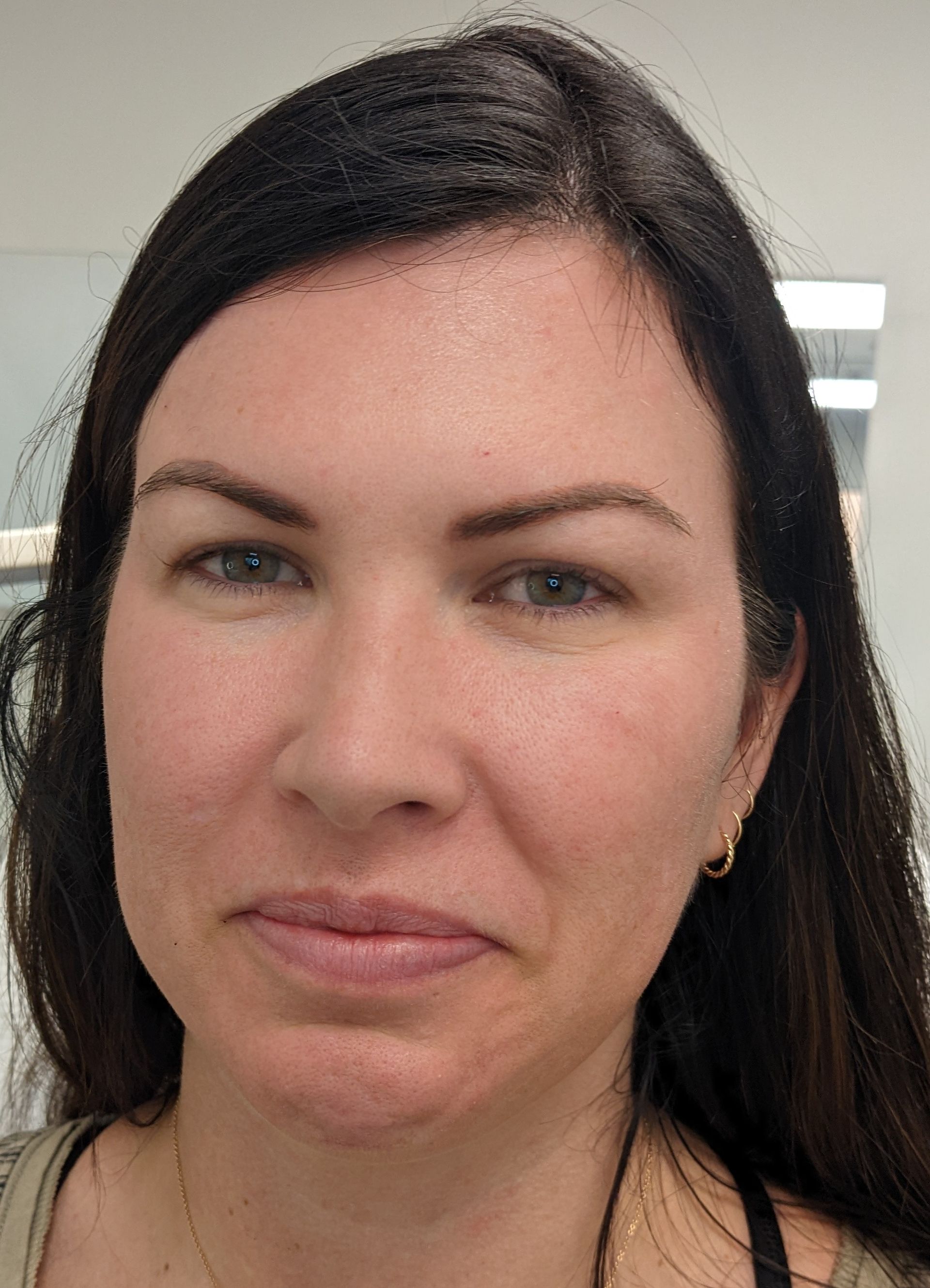 A close up of a woman 's face with a serious look on her face.