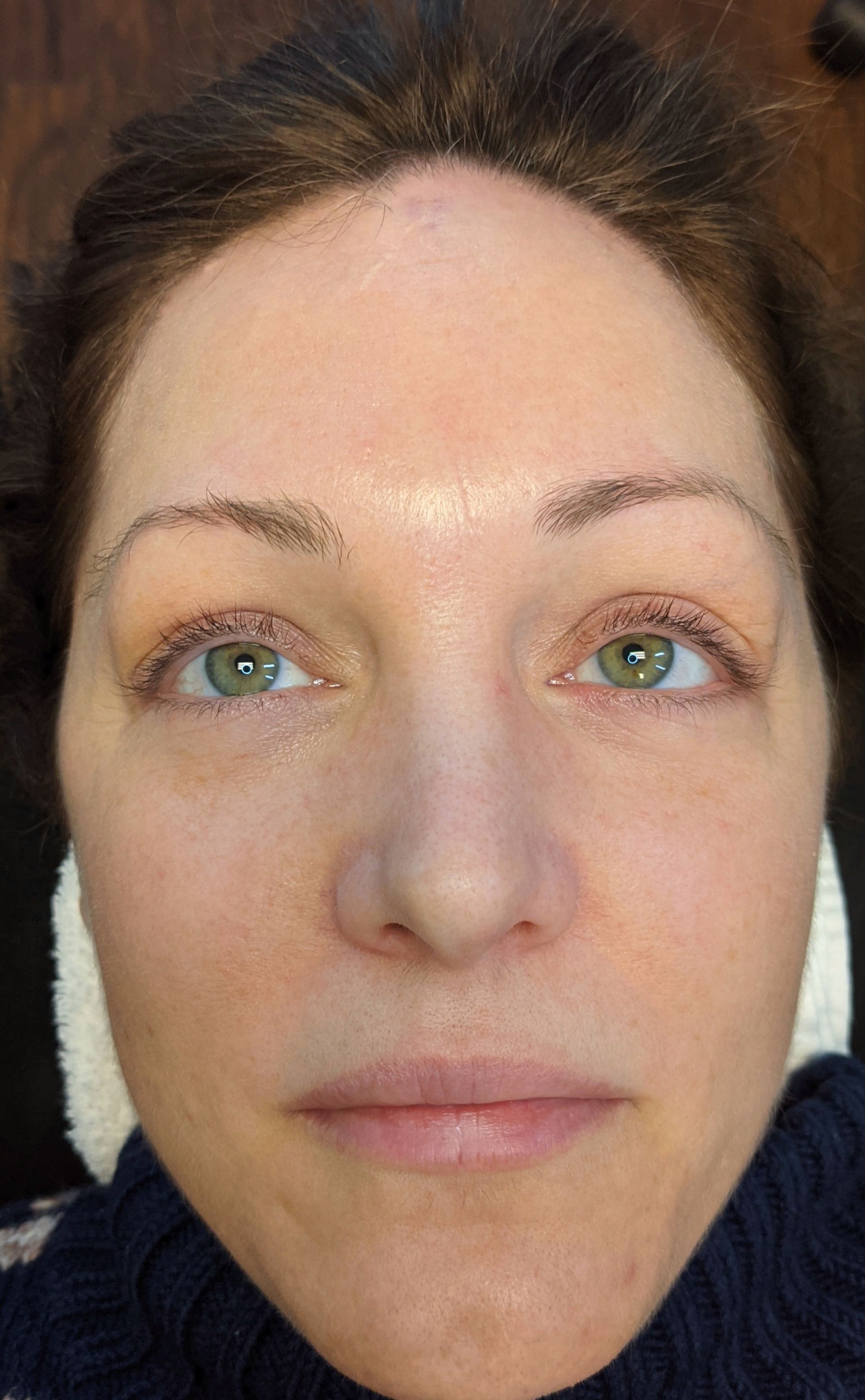 A close up of a woman 's face with green eyes.